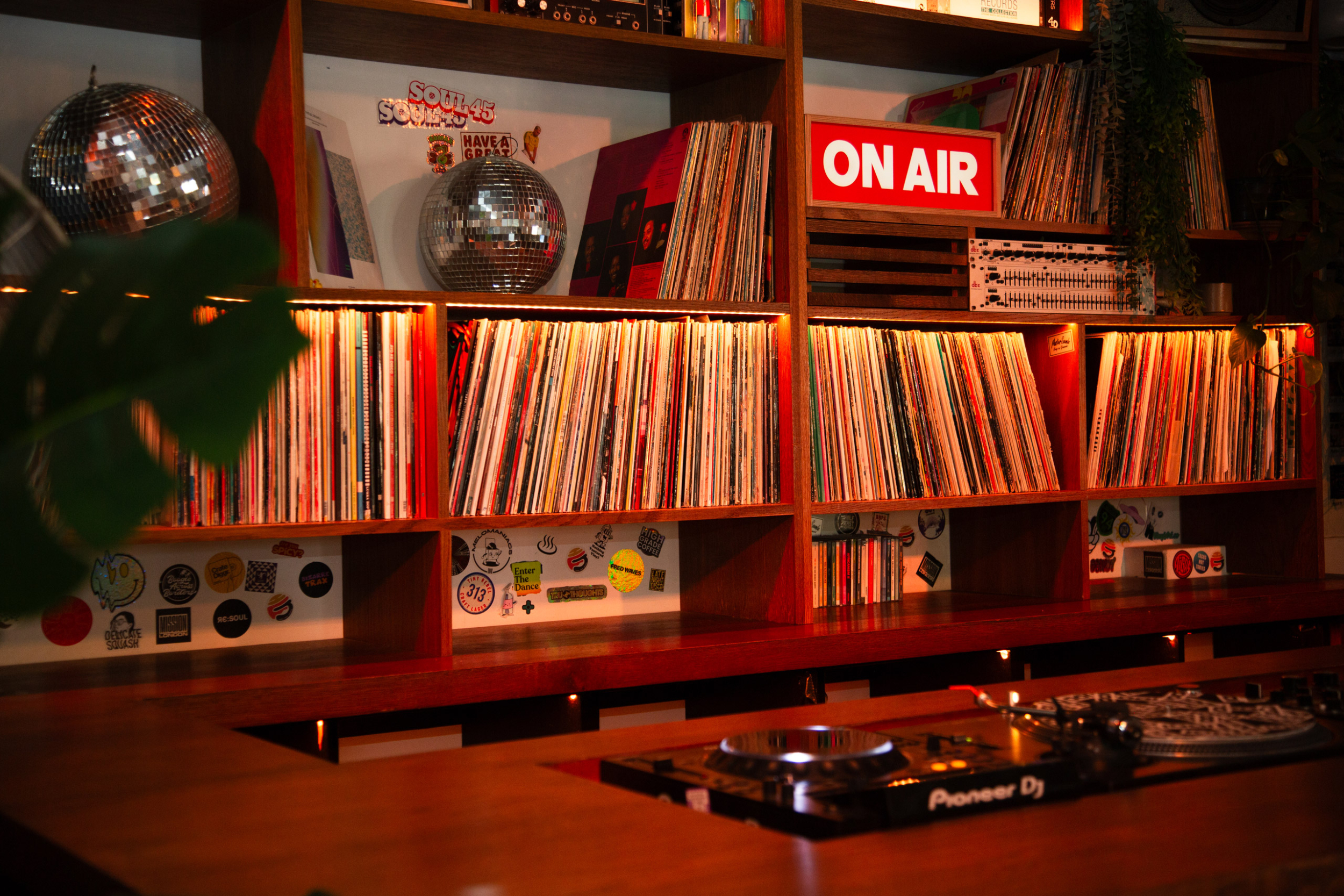 Bespoke vinyl shelving and custom DJ booth at Cafe 1001 with a rotary mixer